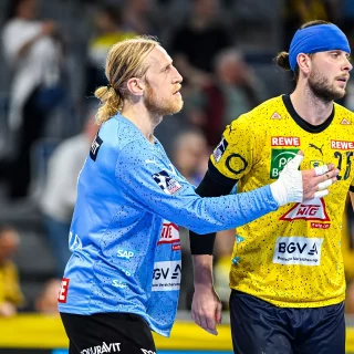 Mikael Appelgren baut Olle Forsell Schefvert auf, welcher nach einem Zusammenstoß eine blaue Bandage um den Kopf trägt.