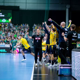 Maik Machulla und die Spieler auf der Bank jubeln.